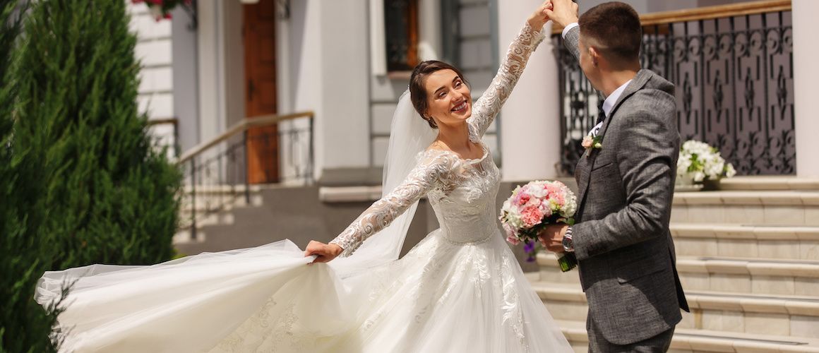 Image of husband twirling bride on wedding day.