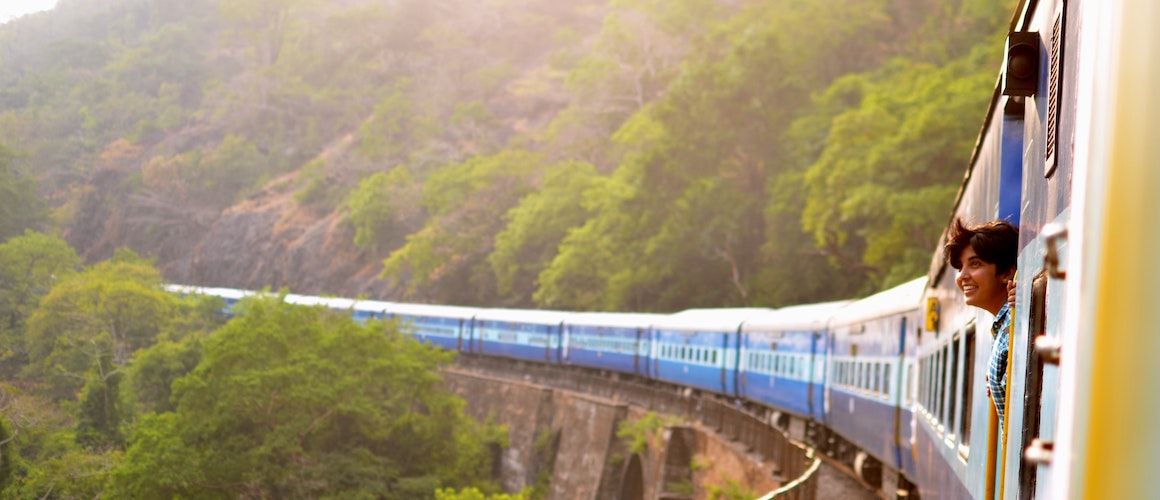 Image of man traveling on cost-effective train, admiring view
