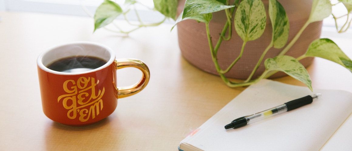Image of motivational coffee mug and notebook.