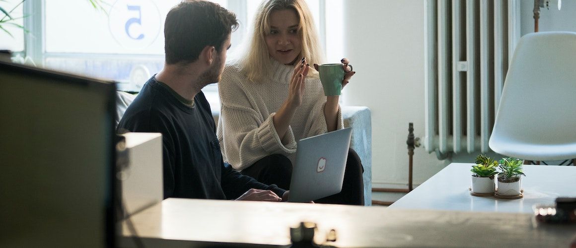 Couple on couch discussing monthly income.