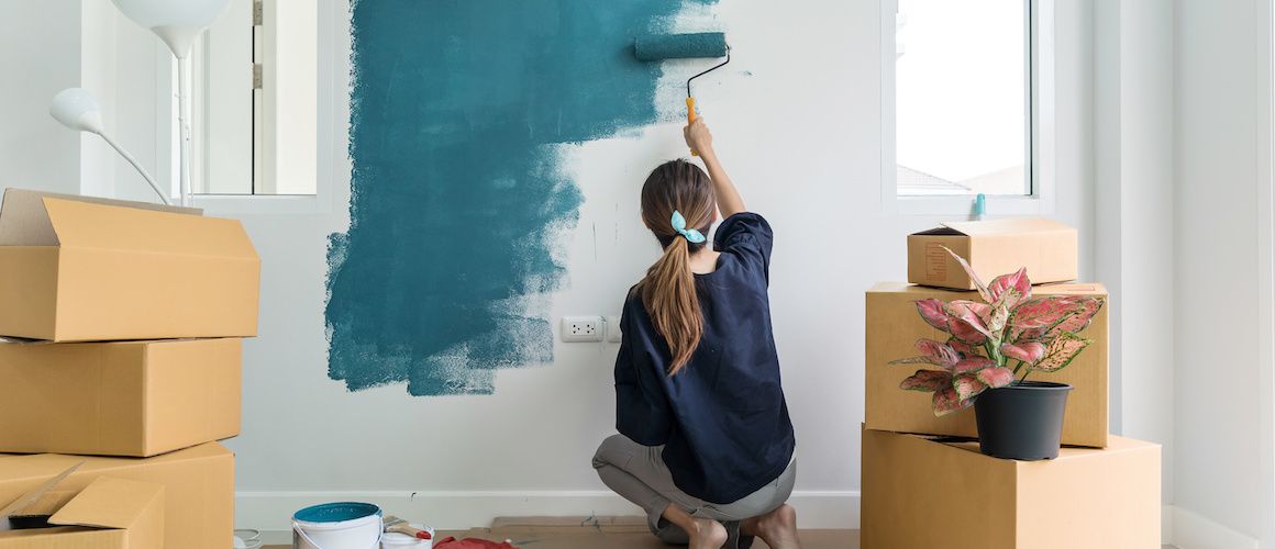 Image of woman painting and working on a home project.