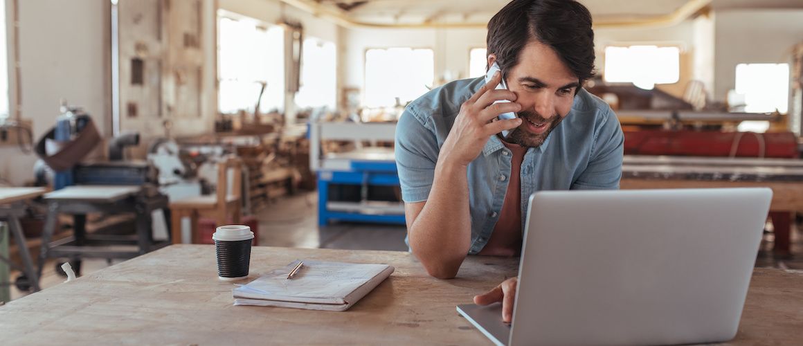 Image of man paying taxes online at coffee shop.