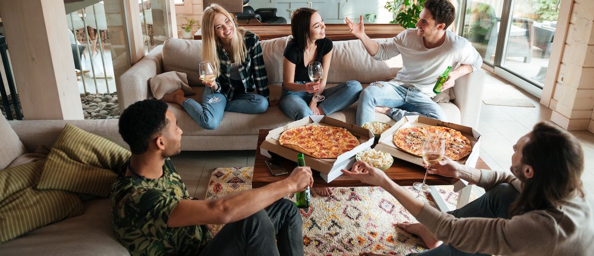 Image of friends gathering around couch in living room.