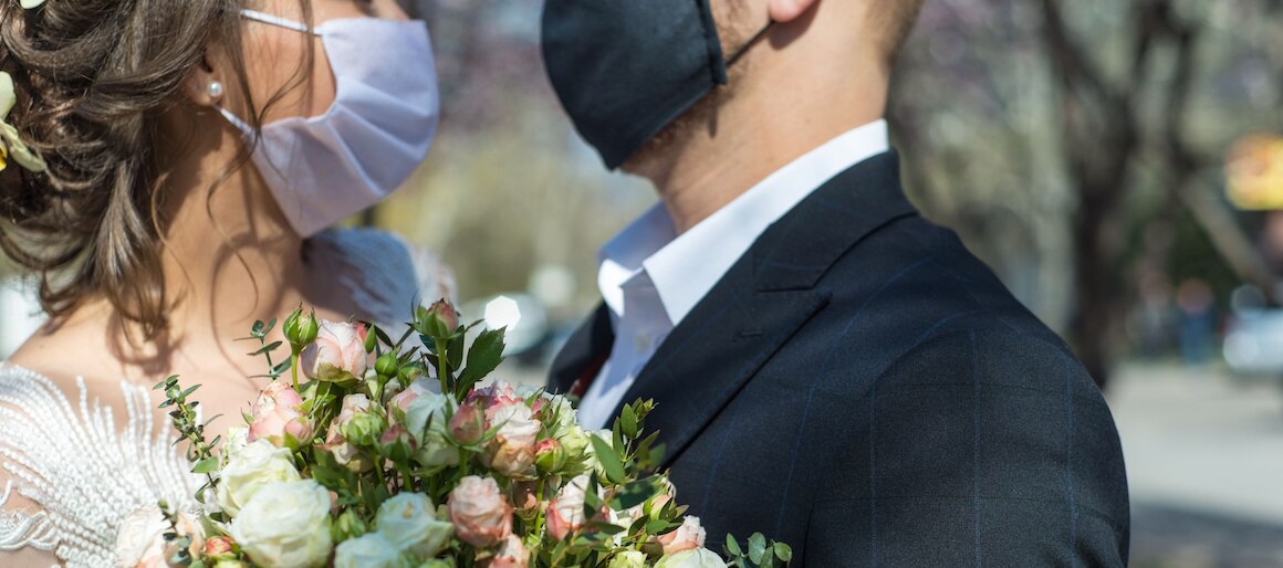 Image of wedding couple wearing face mask.