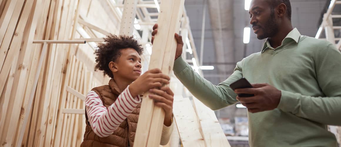 Image of father and son measuring out plywood at the local general store.