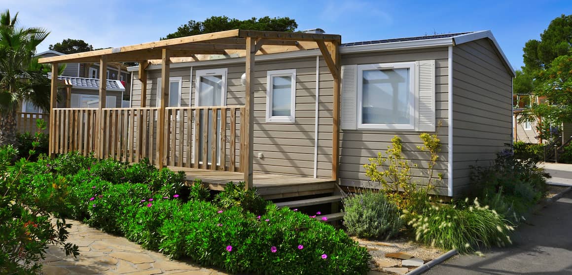 exterior of mobile home with new build on porch and beautiful landscaping