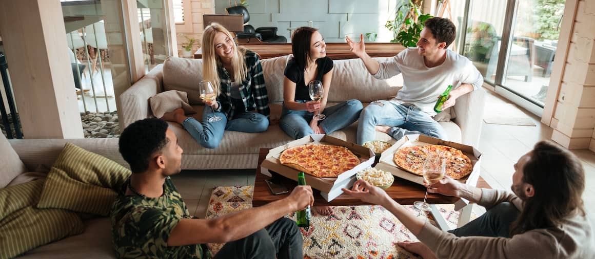 Friends gathering for a party with pizza.