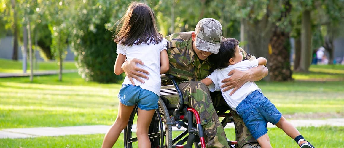 military vet in wheelchair hugging kits