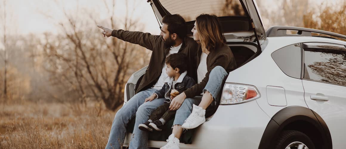 Happy Family Sitting In A Open Trunk Of Hatchback