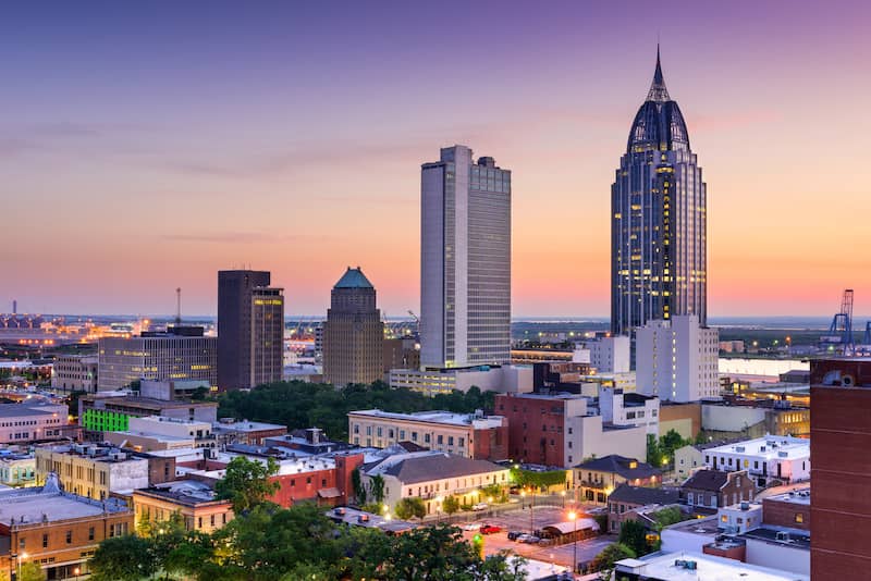 Mobile, Alabama city skyline with skyscrapers at sunset or sunrise.