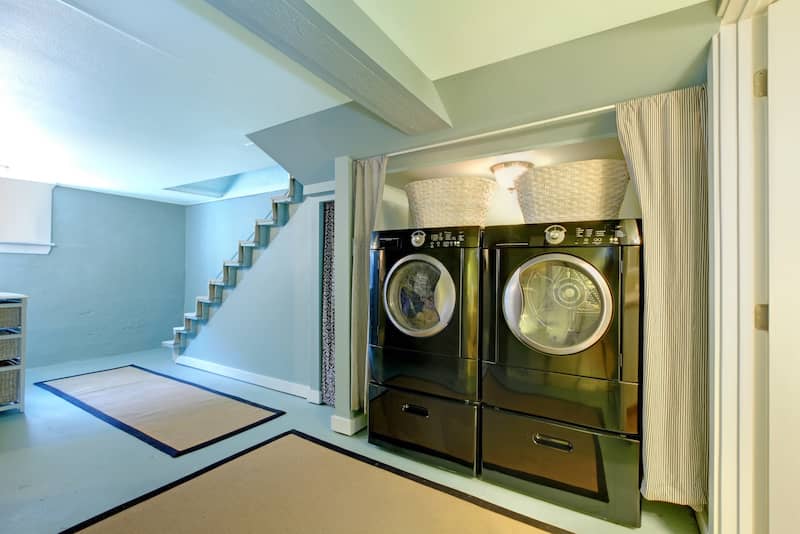 Stairs leading down to basement with washer and dryer.