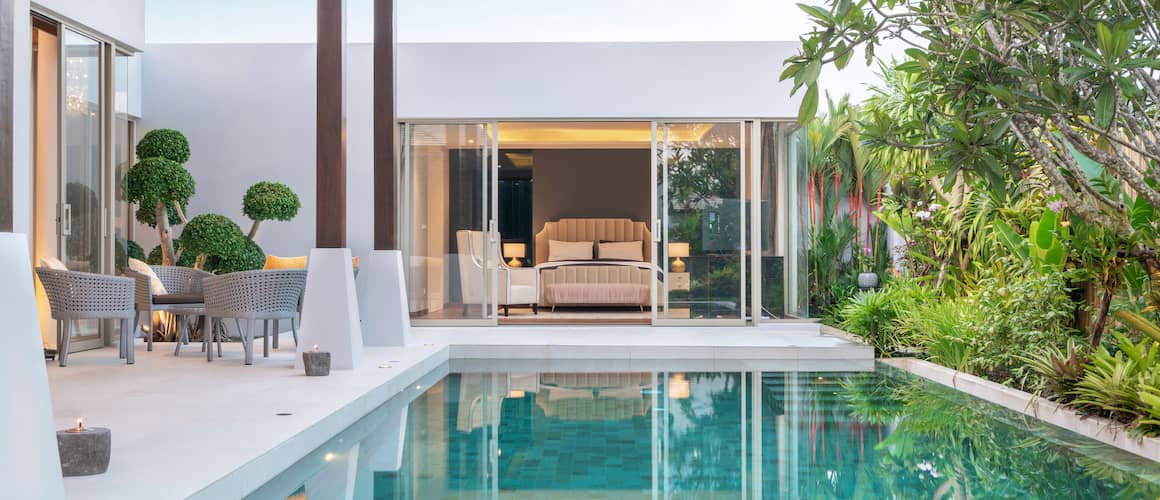 Luxury modern vacation home featuring pool views from bedroom.