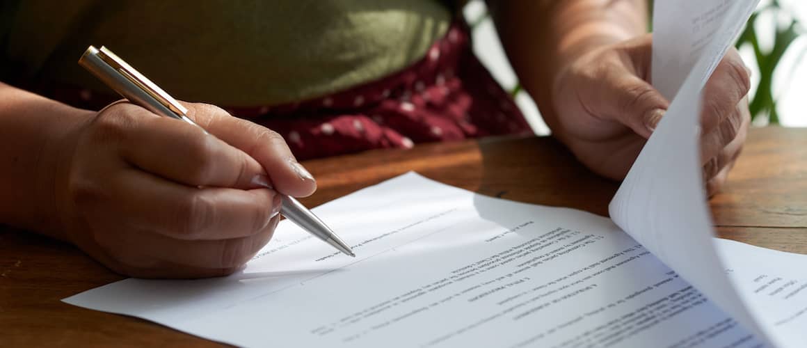 Woman signing papers.