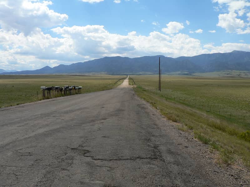 Old and cracked asphalt road with mailboxes.