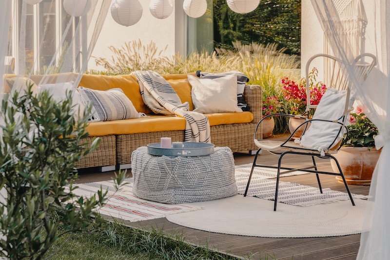 Terrace furniture: pouf used as a table, wicker couch and chair.