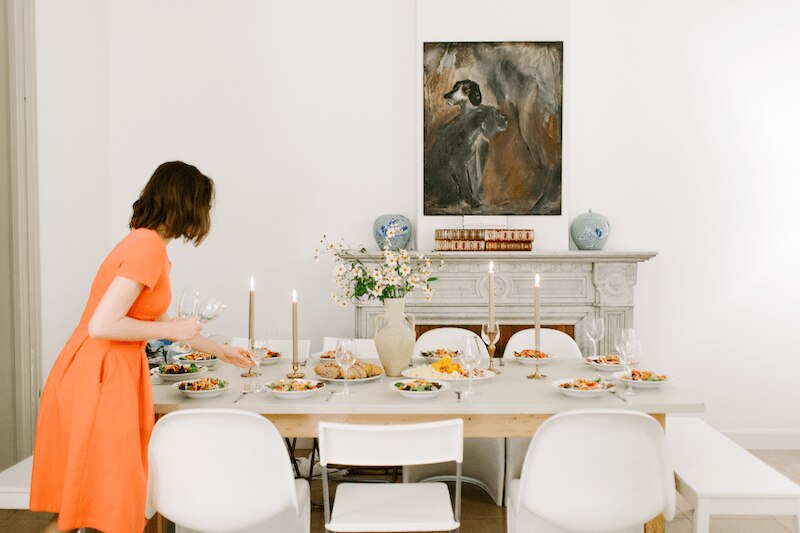 woman in orange dress decorating living room