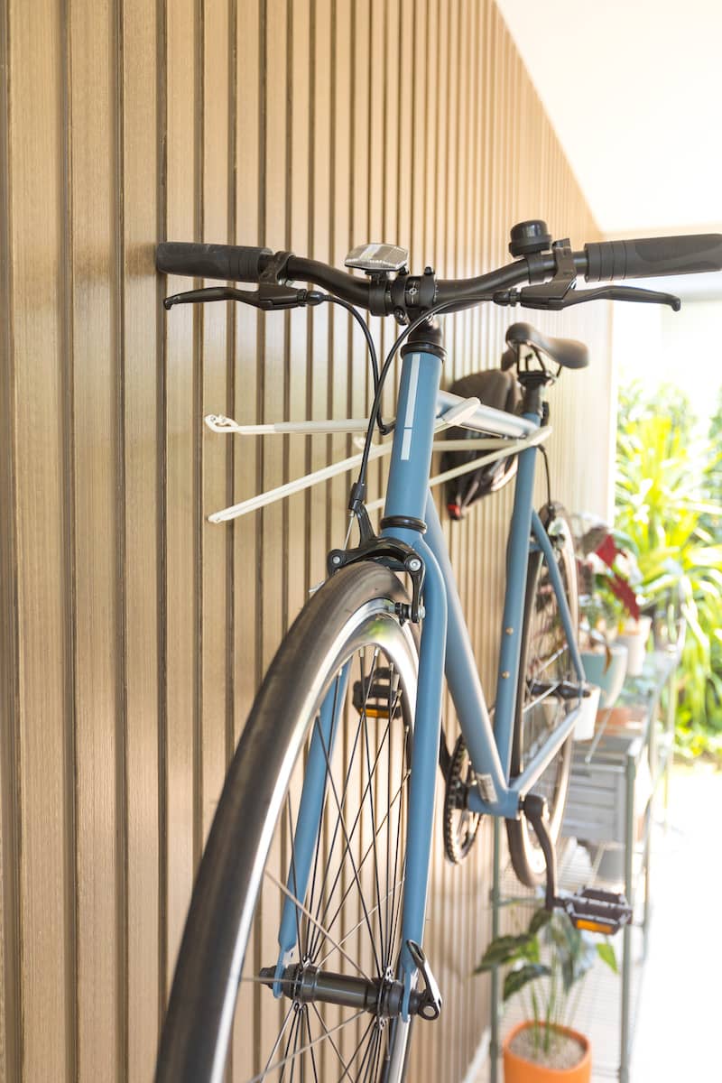 Bike stored on wall of shed using mounted hooks.