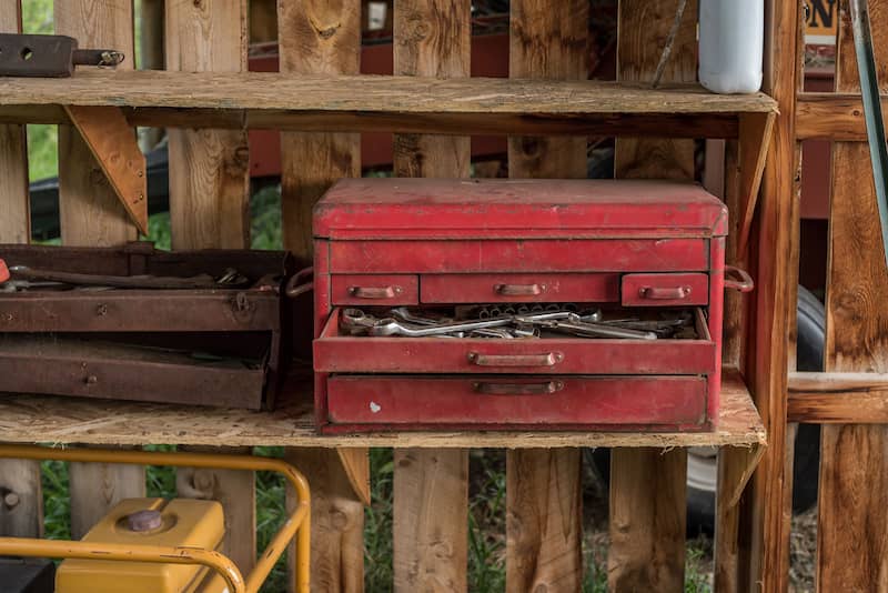Repurposed wood pallet shelving for sheds or garages with tool boxes stored on a shelf.