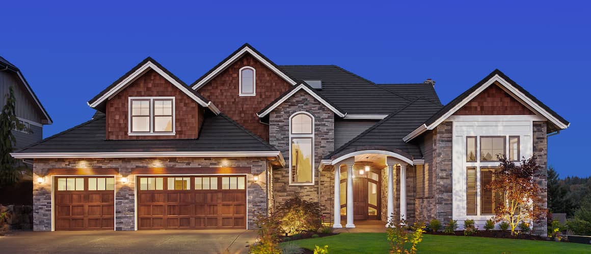 Beautiful brick house with new landscaping against dark blue sky.