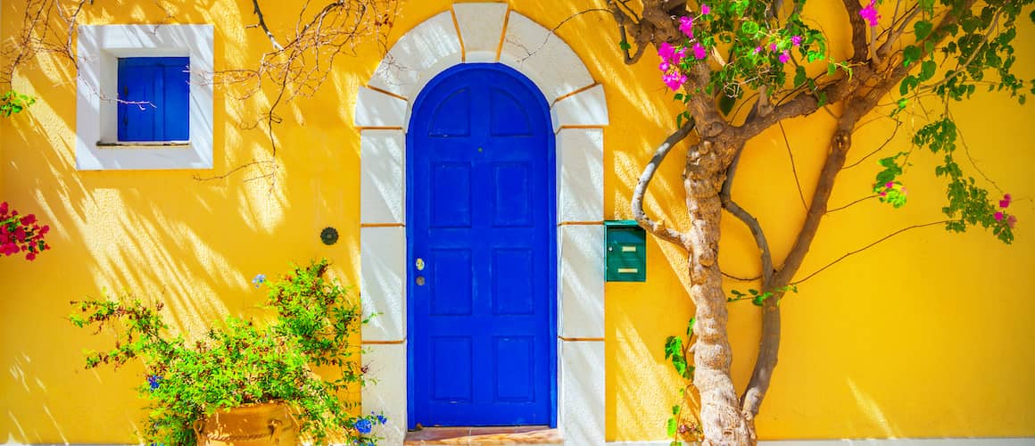 Blue wooden door on yellow house.