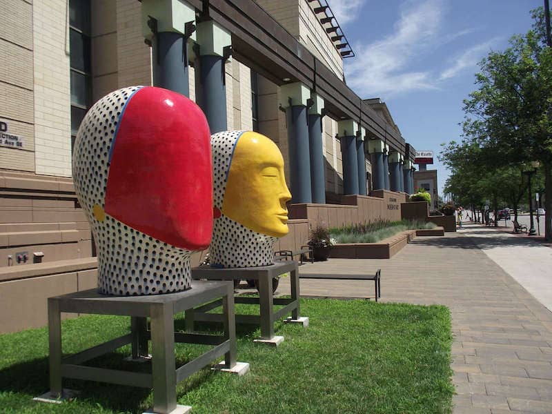 Colorful statue heads displayed outside building in Cedar Rapids, Iowa.