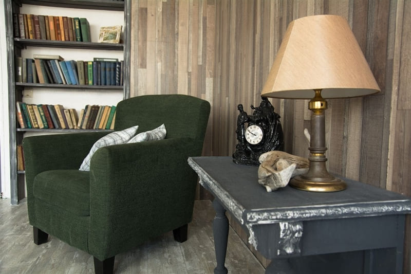 Cozy library with green armchair and bookshelf.