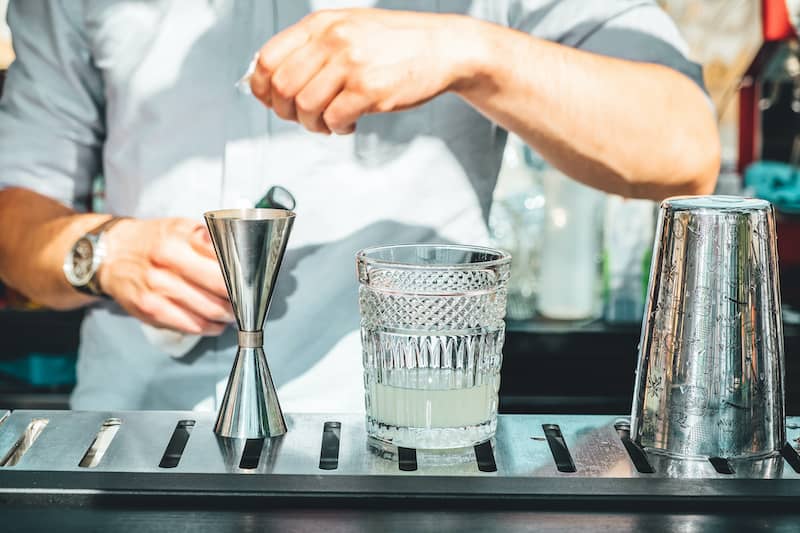 Man Mixing Cocktail With Quality Bar Cart Accessories