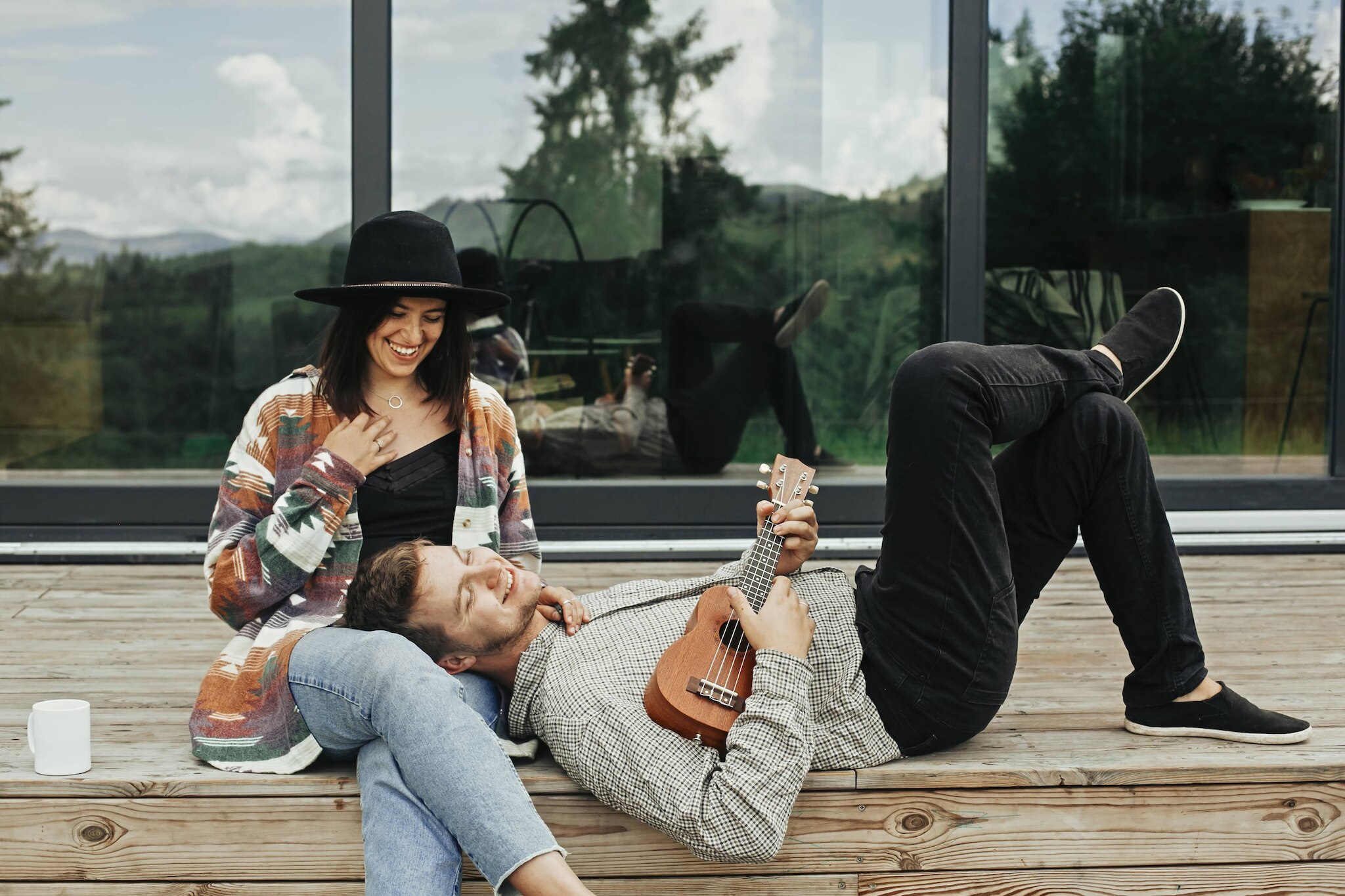 Young Hipster Couple With Ukulele On Back Deck