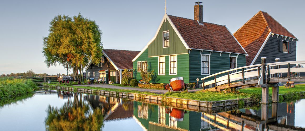 green house on a lake by a bridge