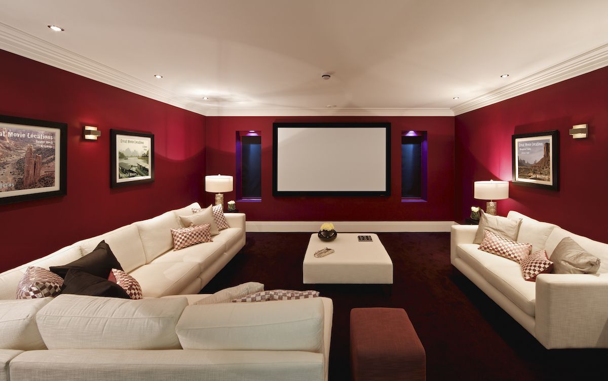 Home theater in basement with red walls.