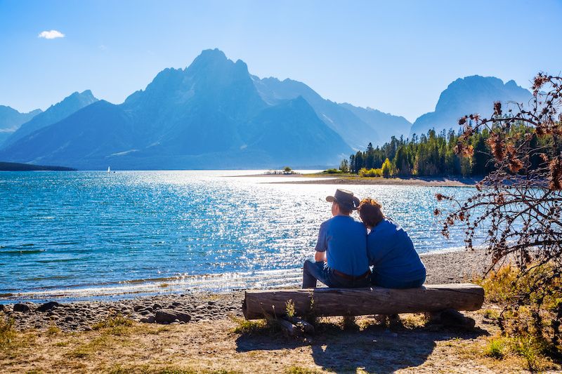 Couple sitting on a bench in Grand Teton National Park in Wyoming admiring the view