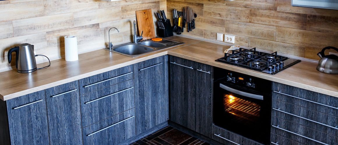Small kitchen with blue-grey wood grain cabinets.