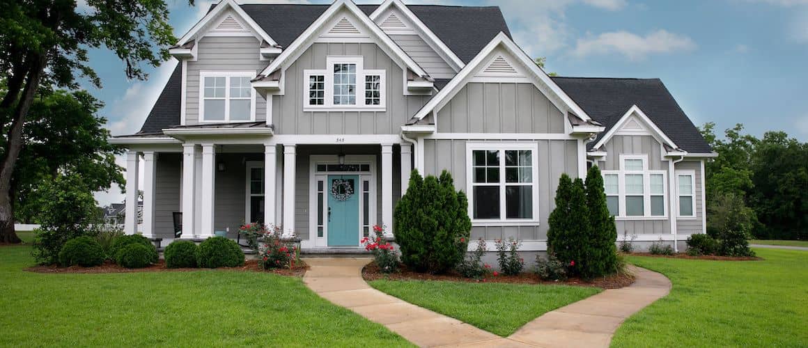 Large house with nice yard and light blue front door.