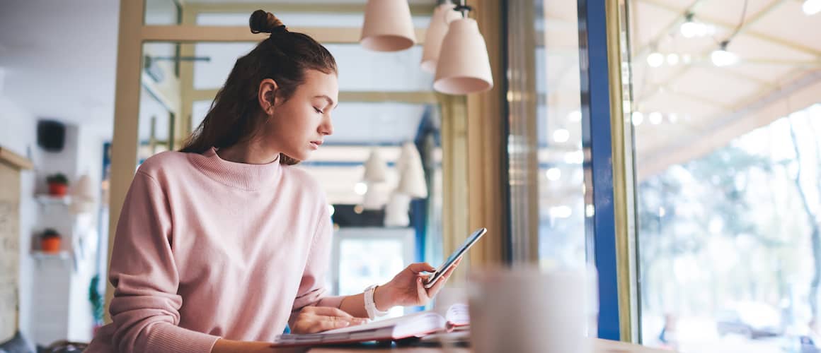 Woman in Coffee shop with bun viewing phone