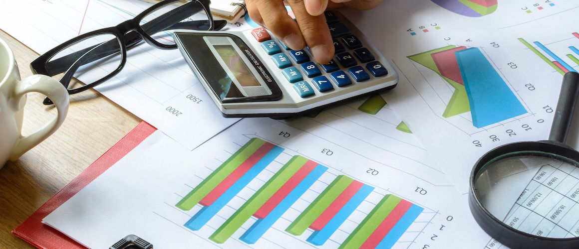 Credit and revenue from sales charts, calculator and glasses.