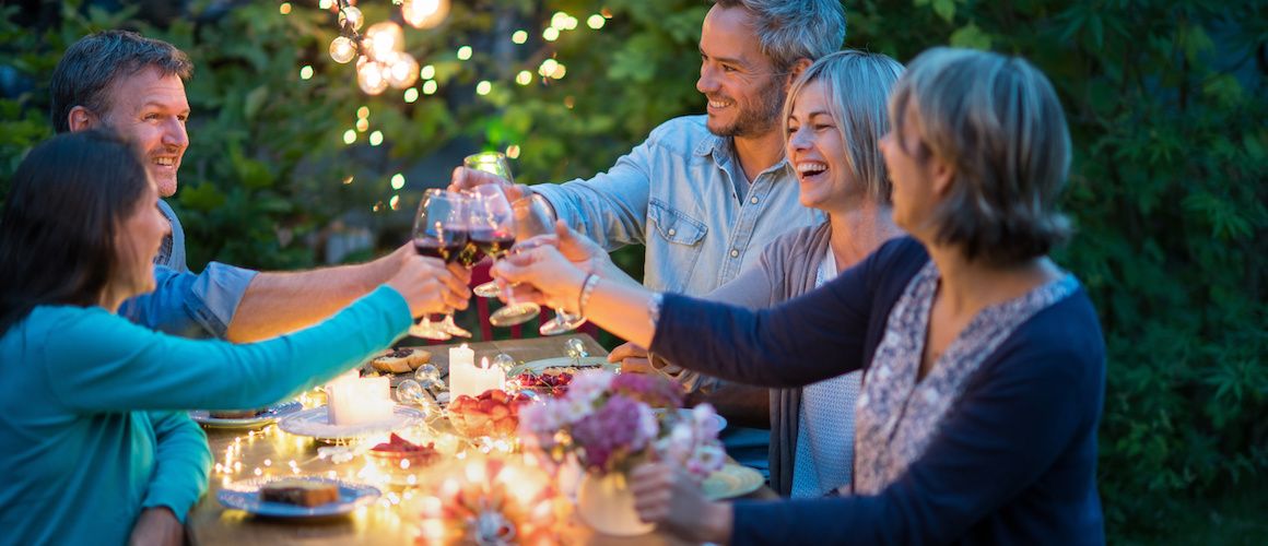 Family enjoying a beautiful backyard picnic to celebrate the sale of their home.