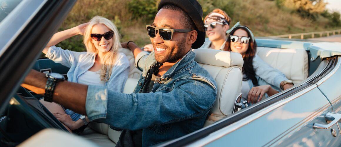 Young friends driving in a convertible.