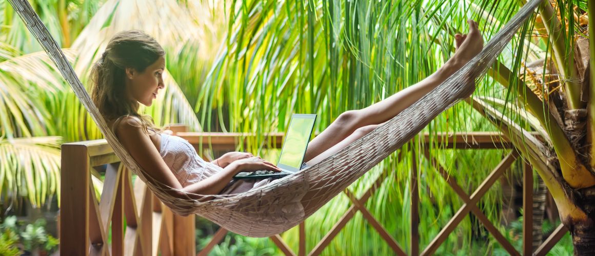 Woman in hammock on her computer.