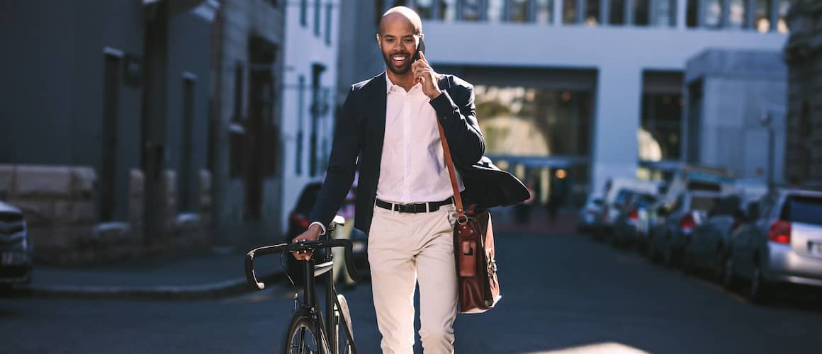 Man on investment call while walking bike.