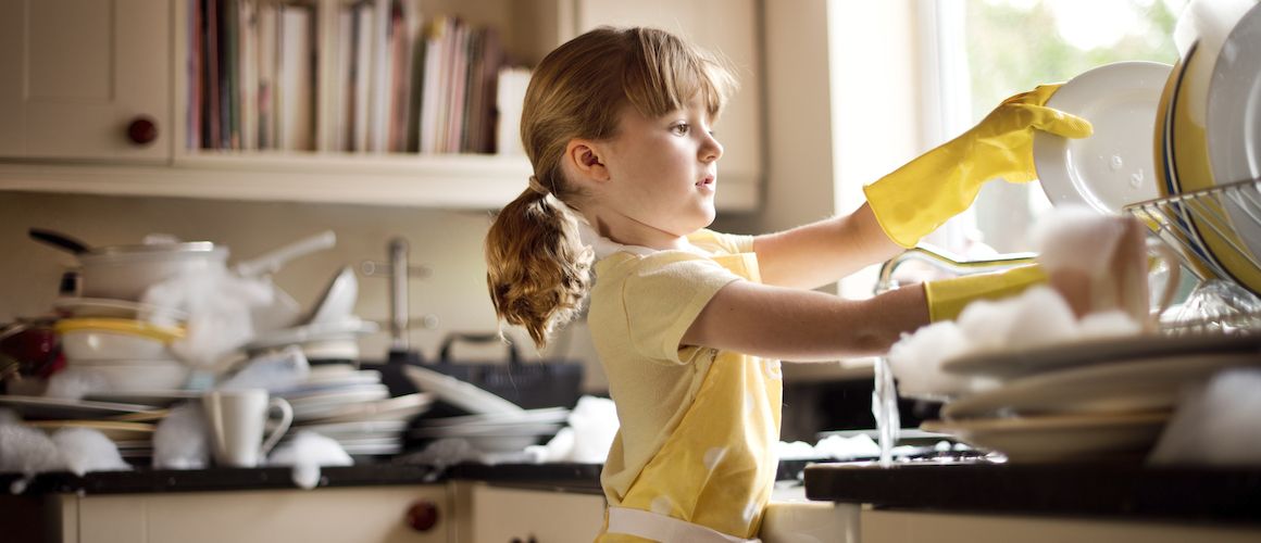 Young girl washing dishes.