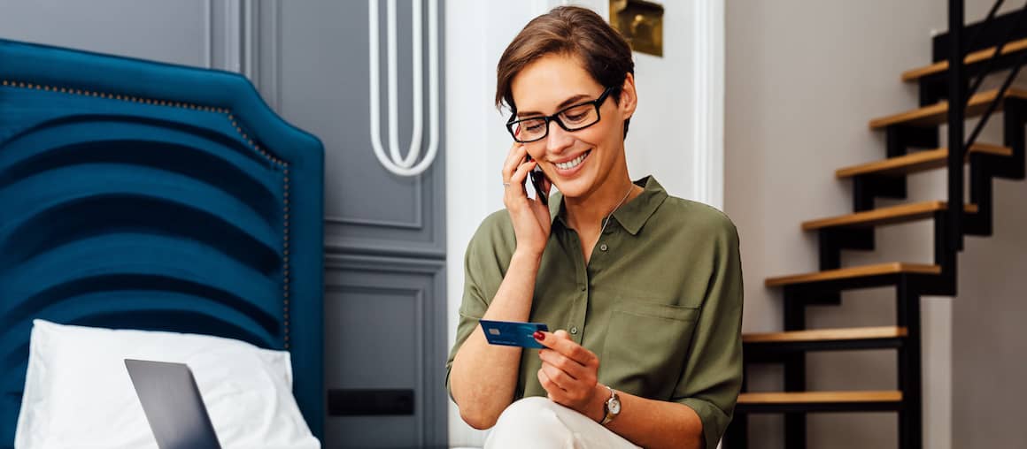 woman on the phone and looking at credit card