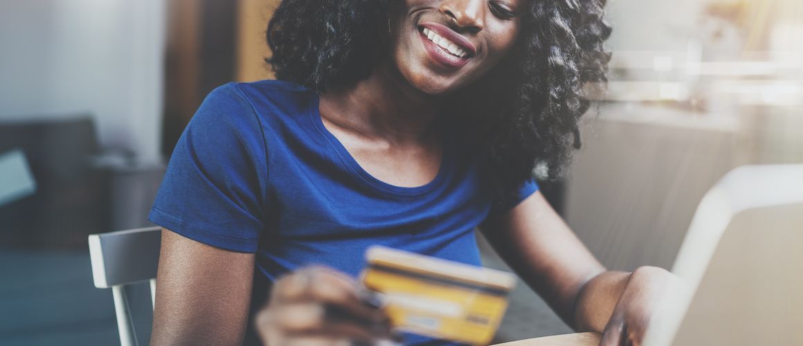 woman shopping online on her laptop with credit card in hand