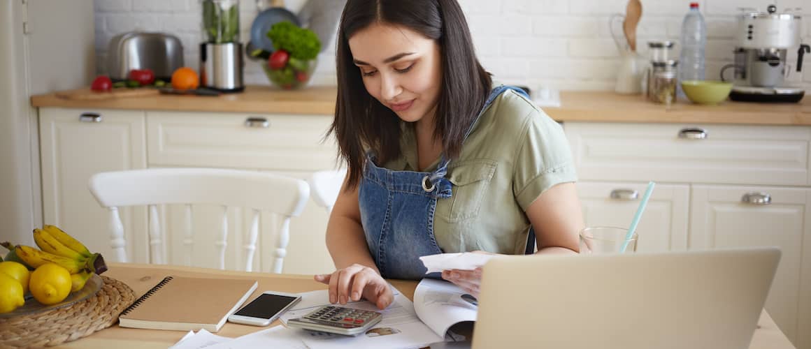 Woman working on finances and budget in the kitchen.