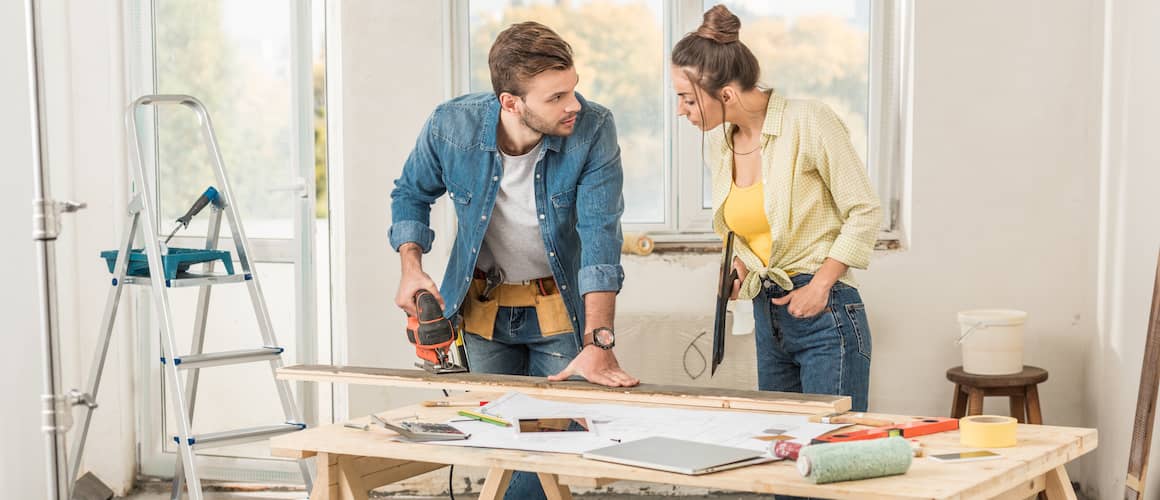 Young Couple Cutting Wood For Renovations