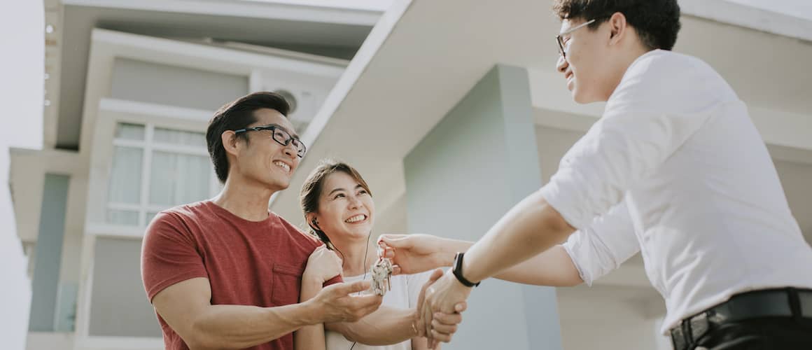 agent handing couple keys to house